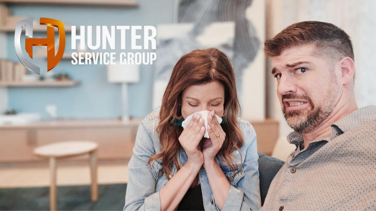 Woman with tissue and concerned man, featuring Hunter Service Group logo; related to HVAC and electrical service advice.